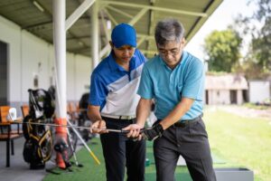 Golf instructor teaching senior student how to play