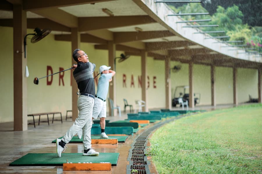 Golfers practicing swings on driving range